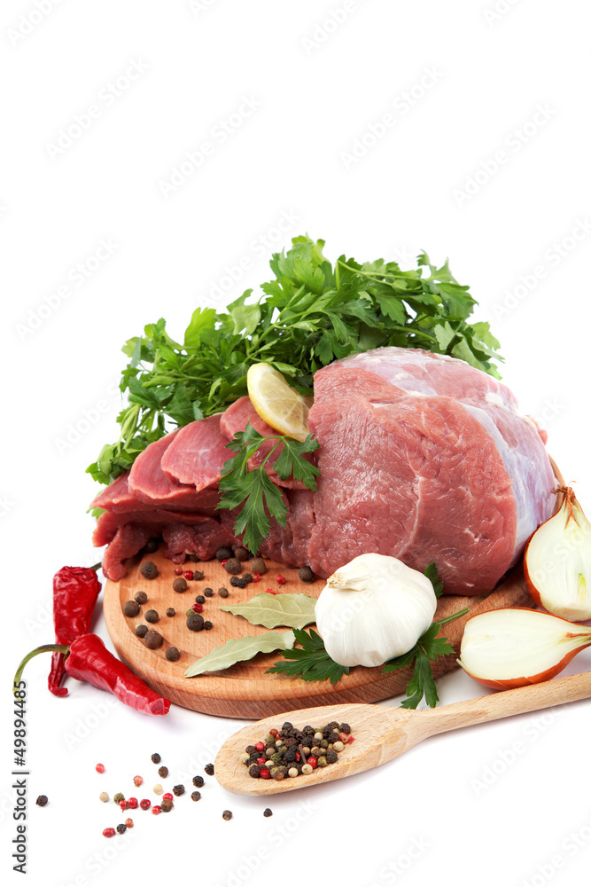 Raw meat, vegetables and spices on a wooden cutting board isolat