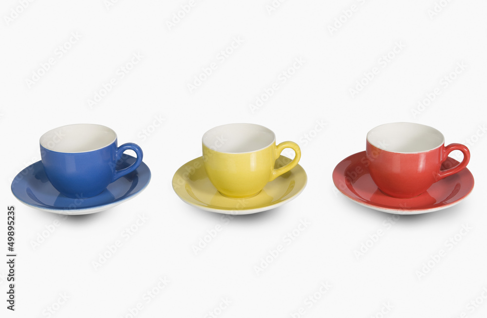 Fototapeta premium Colorful tea cups with saucers in a row
