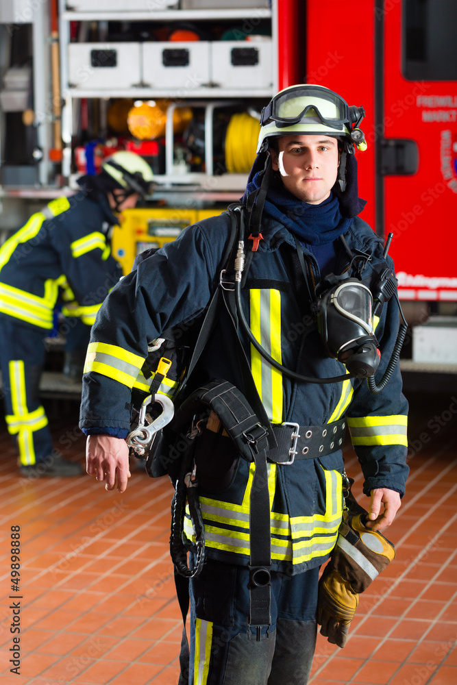 Feuerwehrmann steht in Uniform vor einer Feuerwehr Feuerwehrmann steht in Uniform vor einer Feuerwehr
