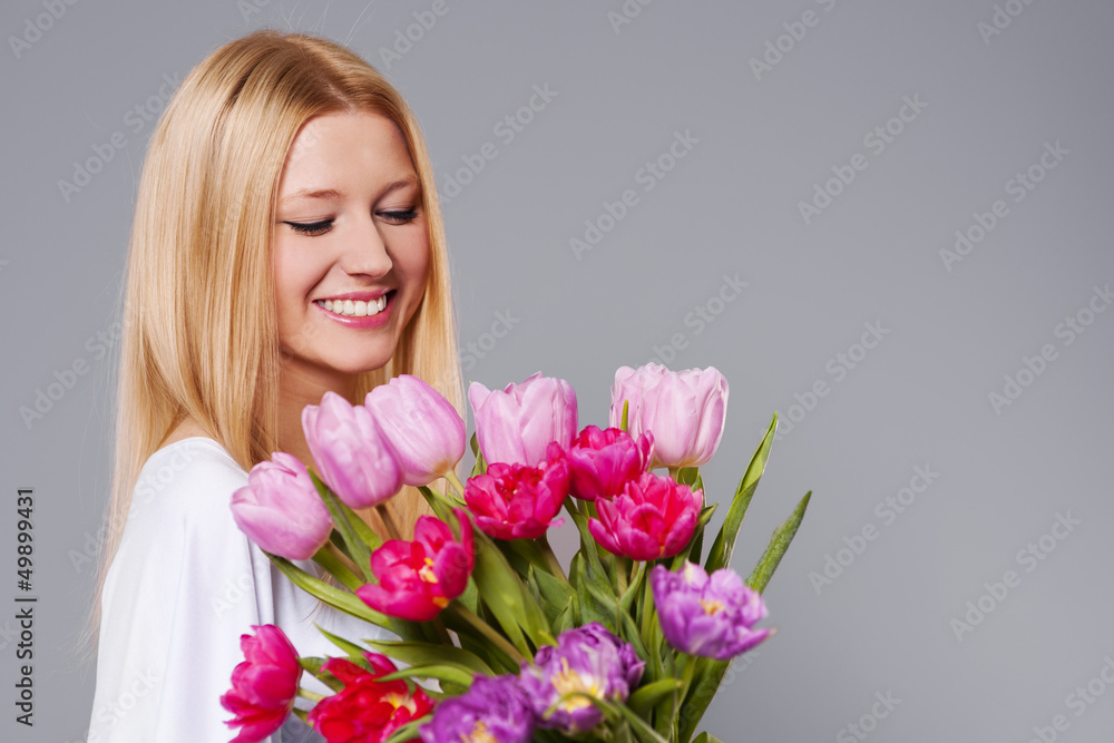 Happy woman holding pink and purple tulips.