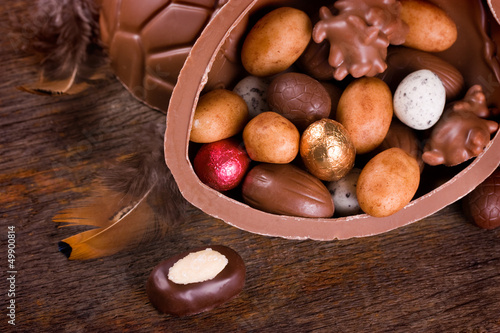 Großes Schokoei gefüllt mit Pralinen und Ostereiern photo