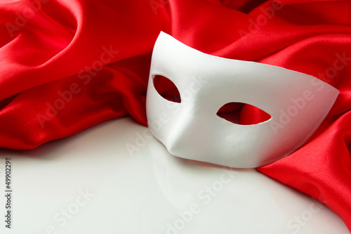 White mask and red silk fabric, isolated on white photo