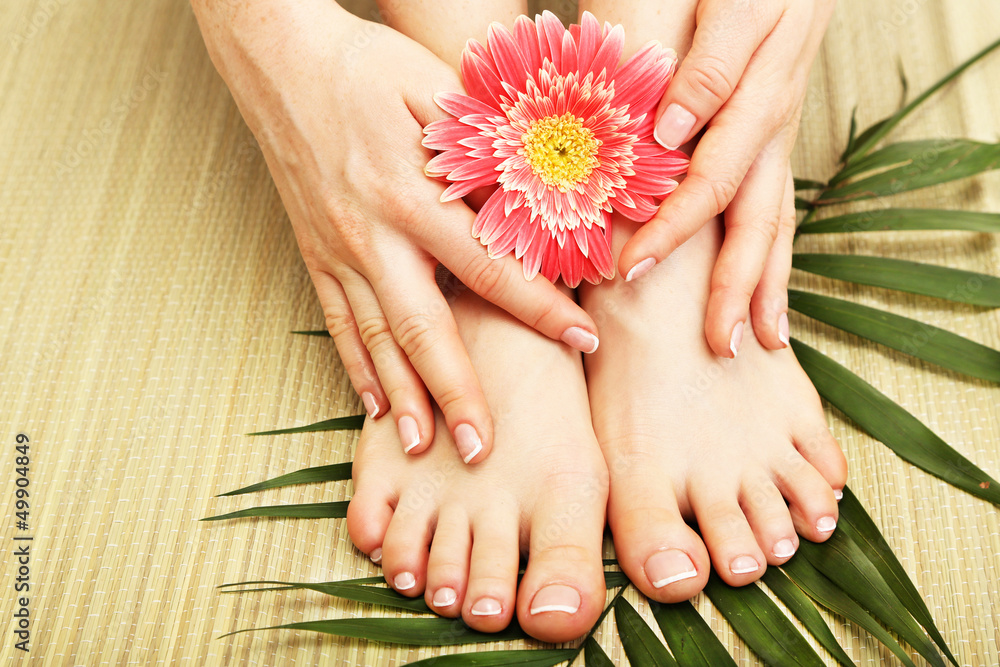 Beautiful woman legs and hands, on bamboo mat