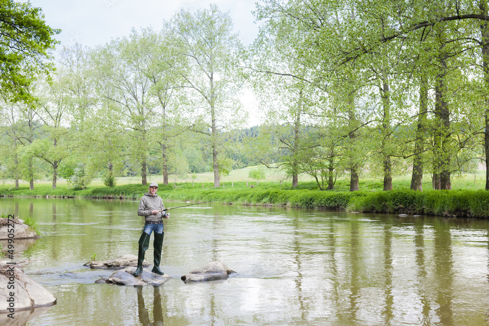 woman fishing in Sazava river, Czech Republic woman fishing in Sazava river, Czech Republic