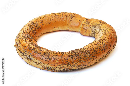 Bagel covered with poppy seeds on a white background.