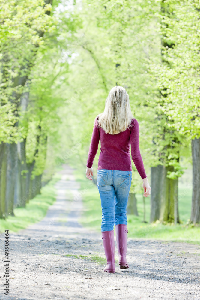 woman wearing rubber boots in spring alley