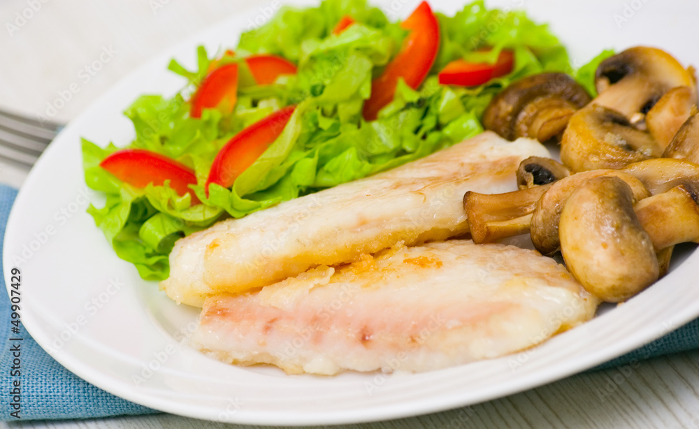 Fish fillet with mushrooms and salad