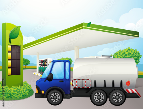 An oil tanker in front of a gasoline station