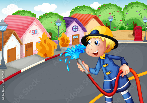 The fireman holding a hose rescuing a village on fire