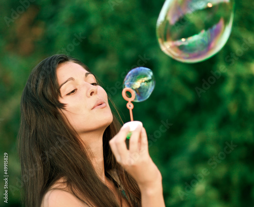 Photos Pretty woman inflating soap-bubbles