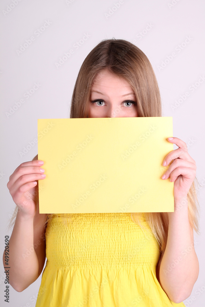 Romantic girl wearing yelow clothing and showing blank card Romantic girl wearing yelow clothing and showing blank card