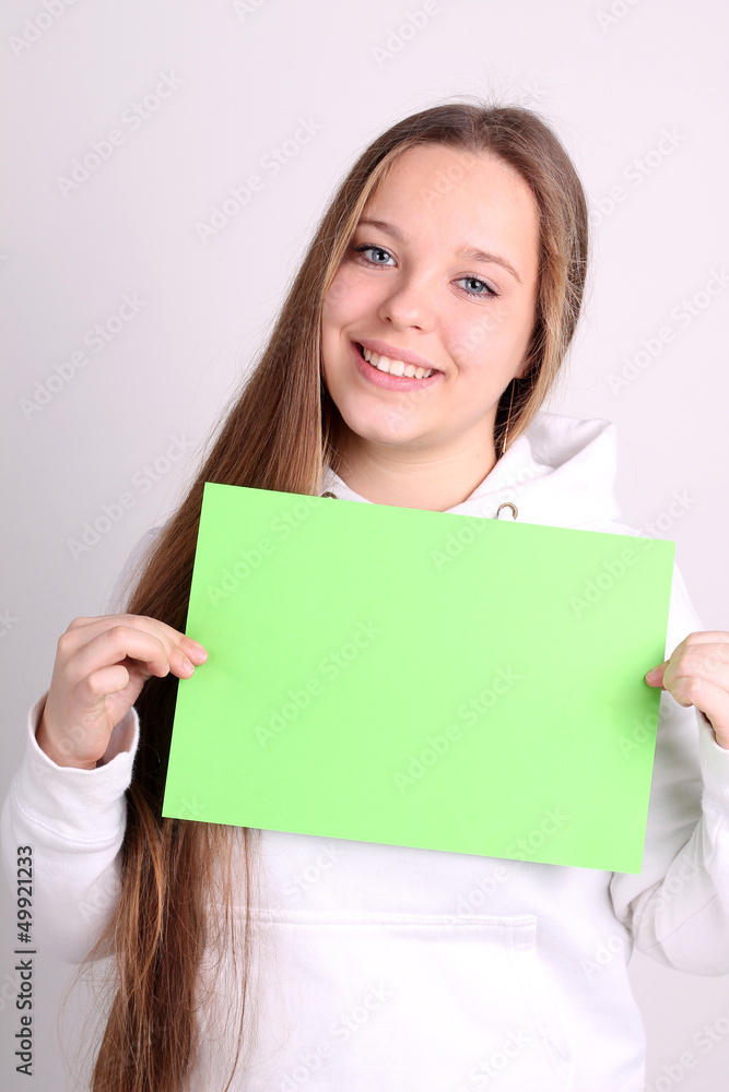 teenage girl wearing sport clothes and showing white blank card teenage girl wearing sport clothes and showing white blank card