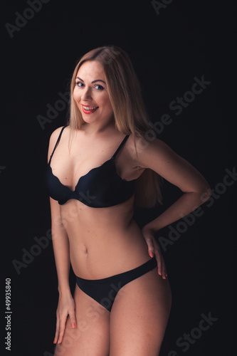 Beautiful and sexy woman wearing sensual lingerie on black backg © Saksoni