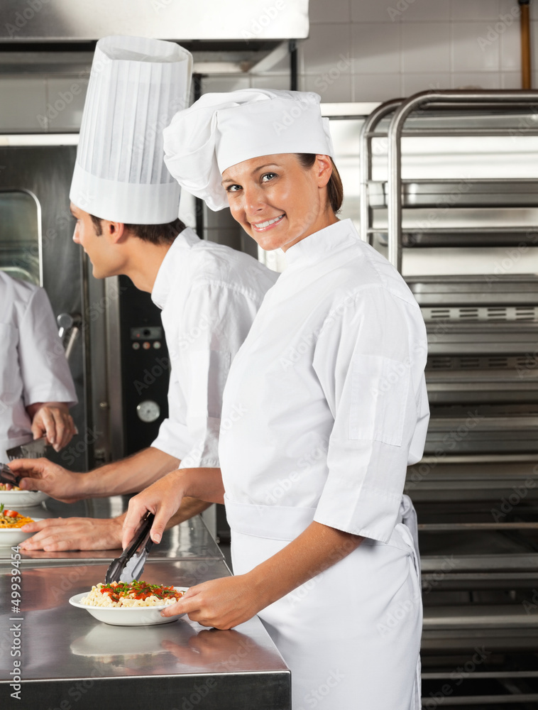 Female Chef Working In Restaurant Kitchen Female Chef Working In Restaurant Kitchen