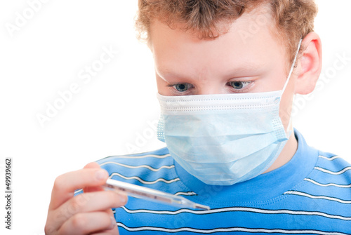 Мальчик в защитной маске с термометром в руках