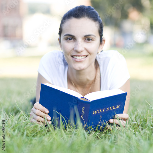 woman reading bible on meadow