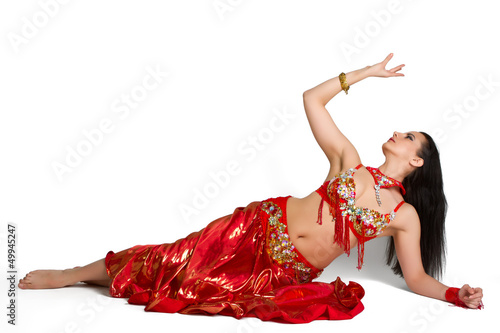 Beautiful young girl in a red suit oriental dance in motion isol