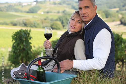 Farmer and wife drinking wine in a vineyard © auremar