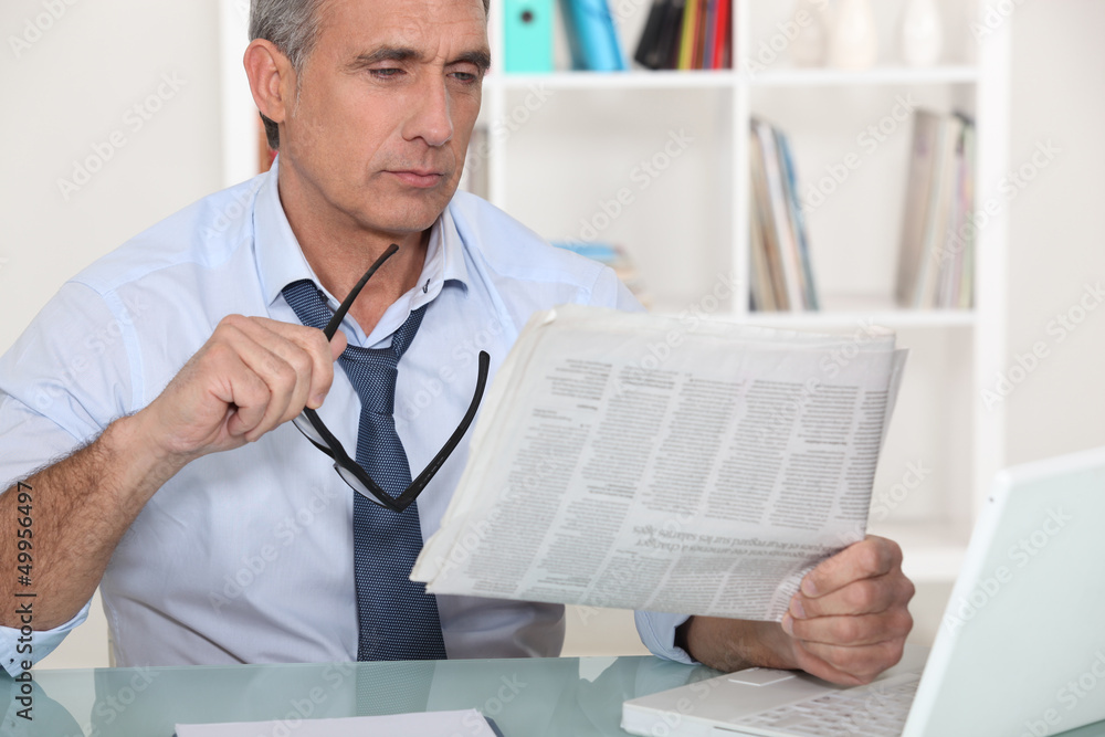 © auremar - businessman reading the newspaper