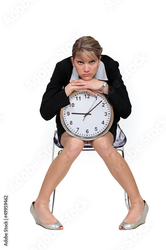 Businesswoman sitting with a large clock photo