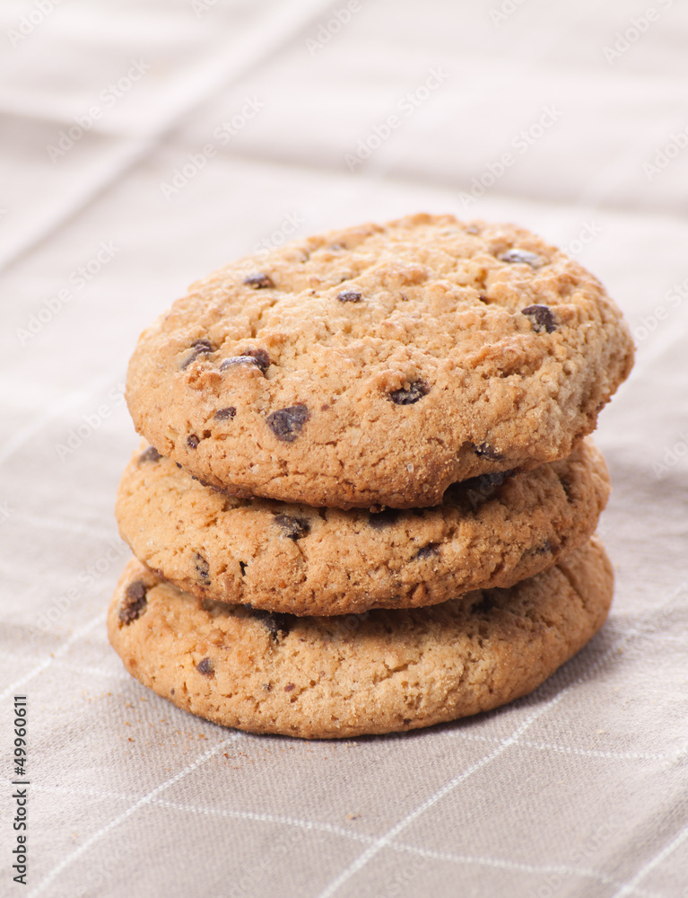 Stacked chocolate chip cookies on brown napkin. Stacked chocolate chip cookies on brown napkin.