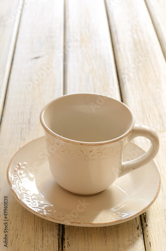 Empty coffee cup of creamy color on wooden table