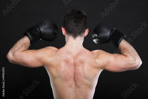 Portrait sportsman boxer in studio dark background back view