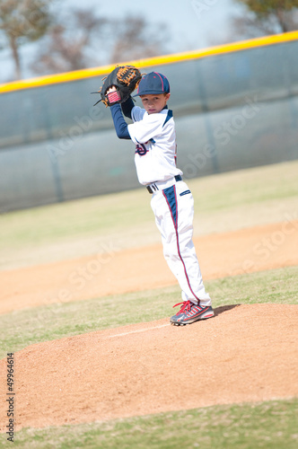 Little league pitcher starting his wind up.