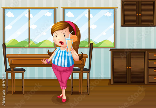 A fat girl holding an orange juice near the table