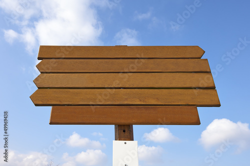 empty wooden sign on blue sky background © pbombaert