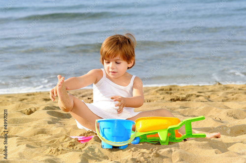 Happy toddler girl playing with her toys at beach Happy toddler girl playing with her toys at beach