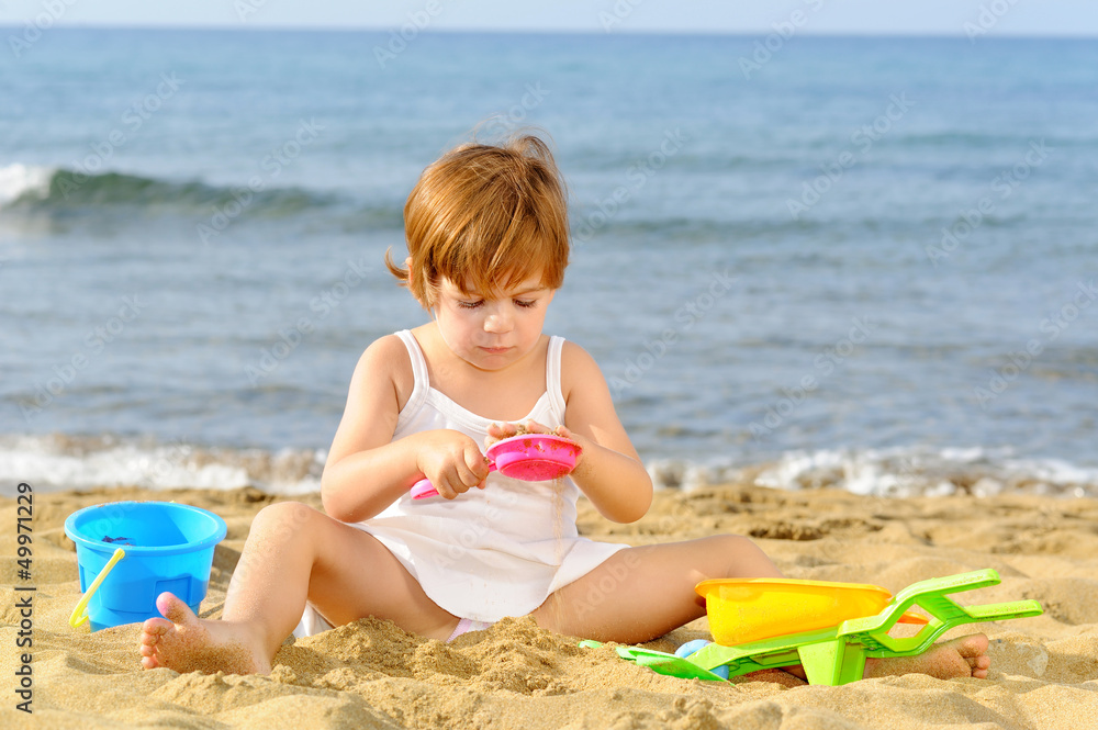Happy toddler girl playing with her toys at beach Happy toddler girl playing with her toys at beach