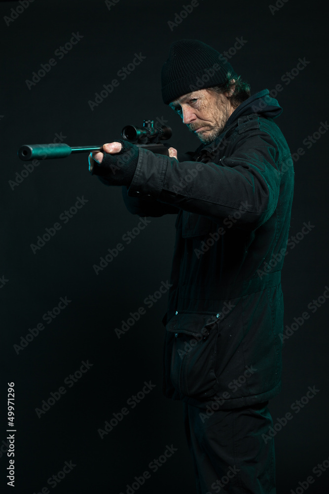 Sniper with beard in black holding gun. Studio shot. Sniper with beard in black holding gun. Studio shot.