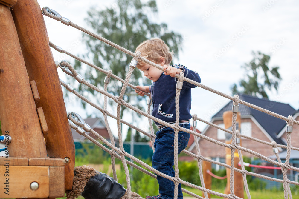 Little toddler boy playing on playground