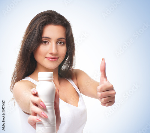 A young and happy brunette holding thumbs up and a bottle