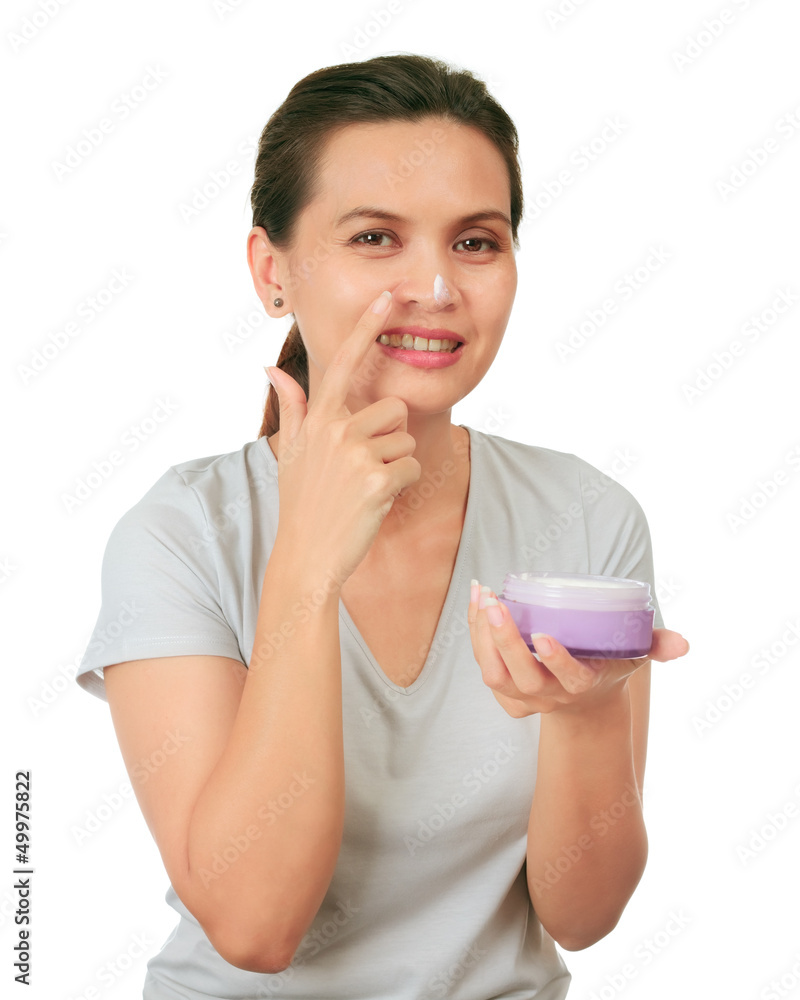 Isolated Middle Age Asian Woman apllies cream on her face. Isolated Middle Age Asian Woman apllies cream on her face.