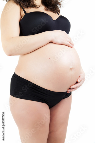 pregnant woman touching her belly with hands