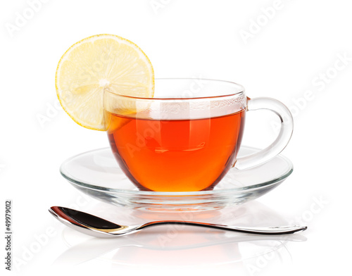 Glass cup of black tea with lemon slice and spoon