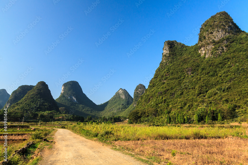 Sand road through a valley with limestone rocks Sand road through a valley with limestone rocks