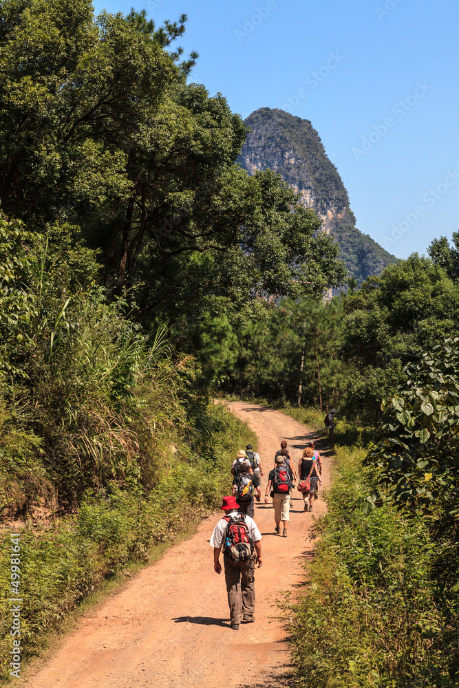 Obraz premium Group of people walking through limestone rock valley