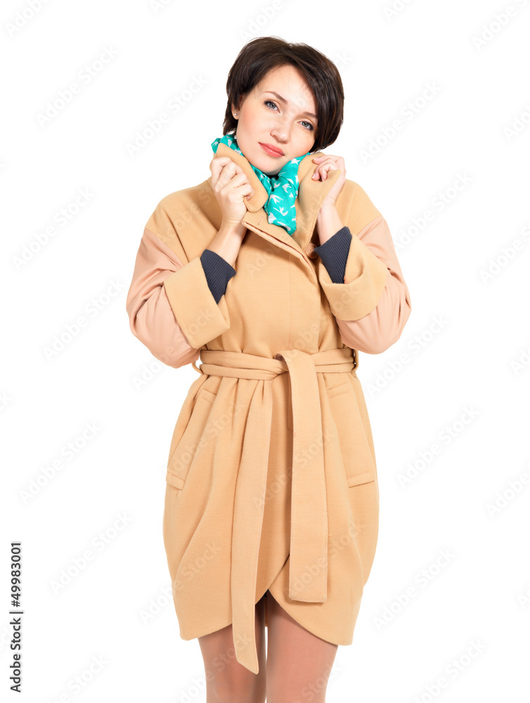 Woman in beige fall coat with green scarf