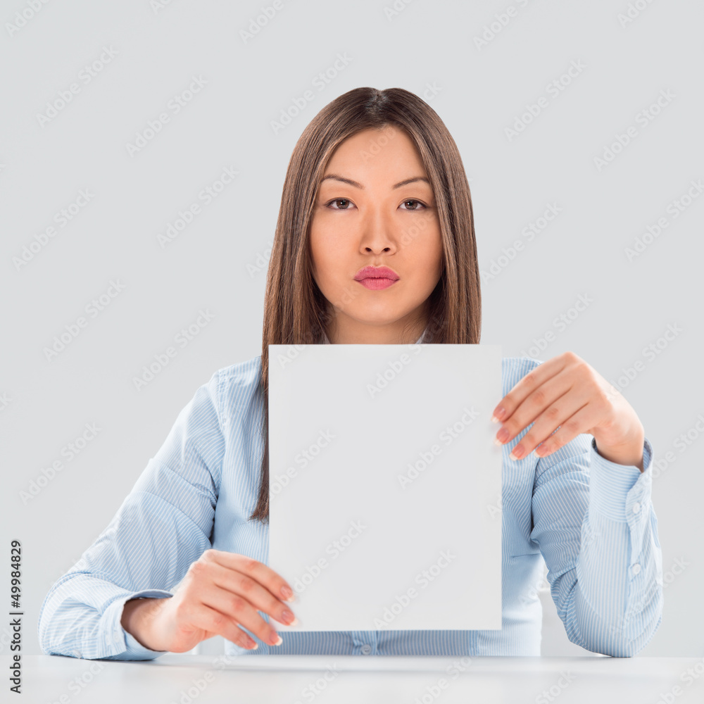 Portrait of business woman with blank sheet over gray background Portrait of business woman with blank sheet over gray background