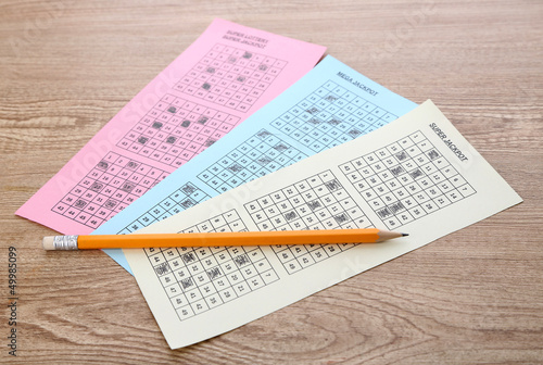 Lottery tickets and pencil, on wooden background