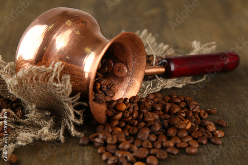 Coffee pot with coffee beans on wooden background