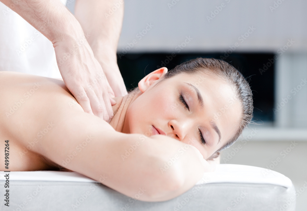 Calm woman receives body massage at spa salon Calm woman receives body massage at spa salon