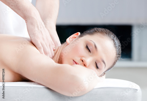 Calm woman receives body massage at spa salon