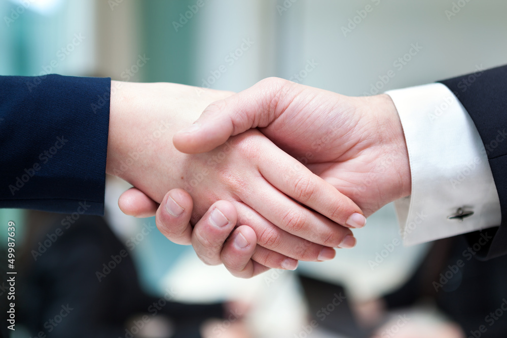 Closeup of business handshake after signing new contract at the