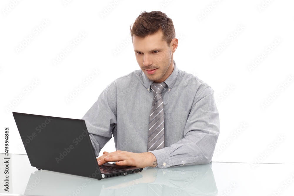 Young man working on laptop smiling Young man working on laptop smiling