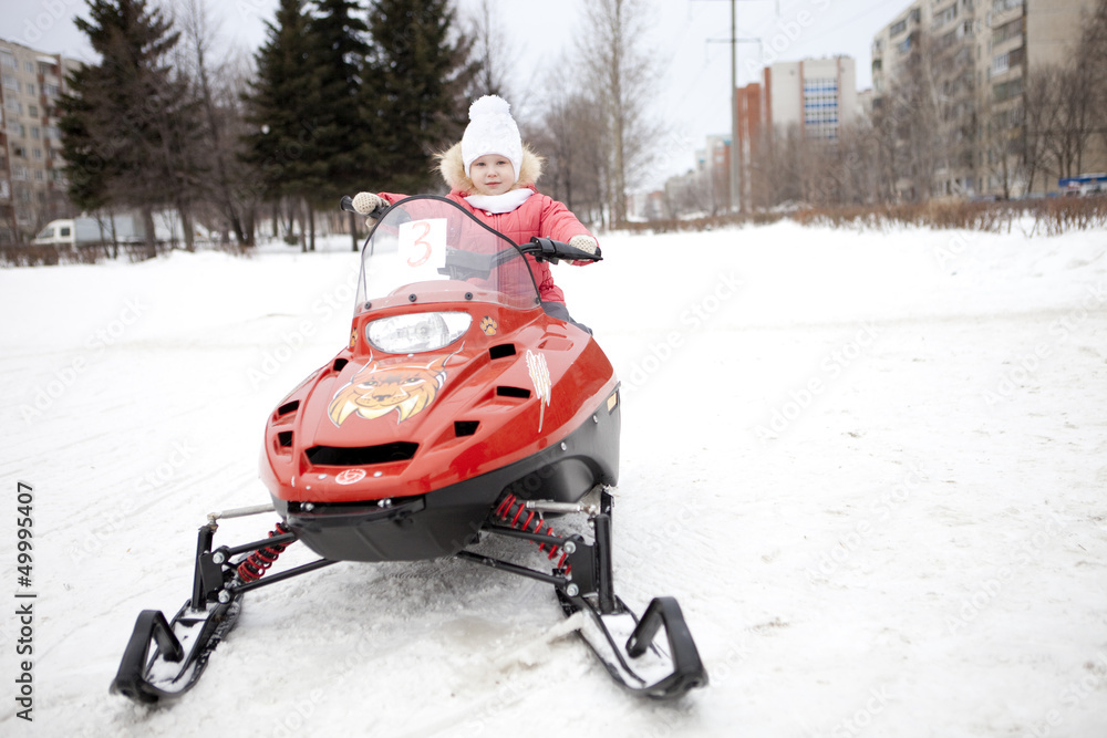 Children are riding on snowmobiles.