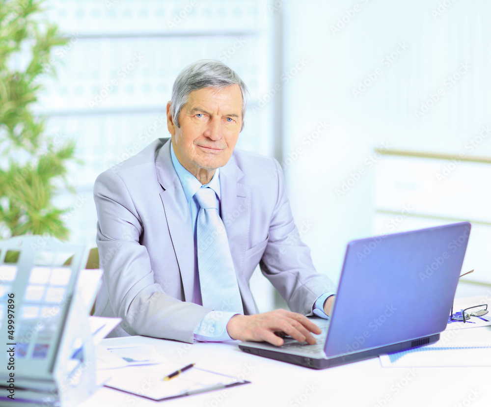 The businessman at the age of works for the laptop.